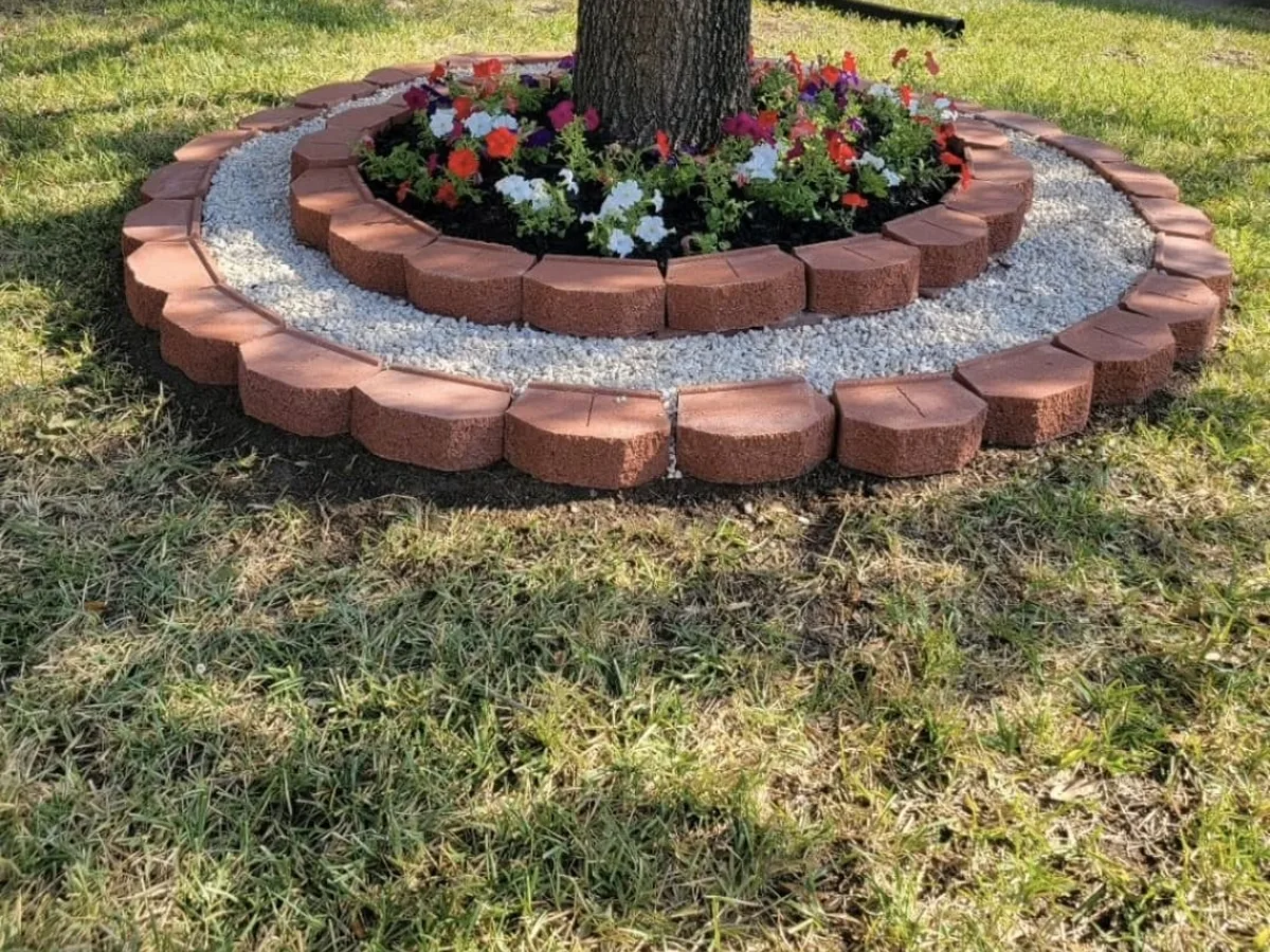Brick-edged tree ring with flowers and gravel