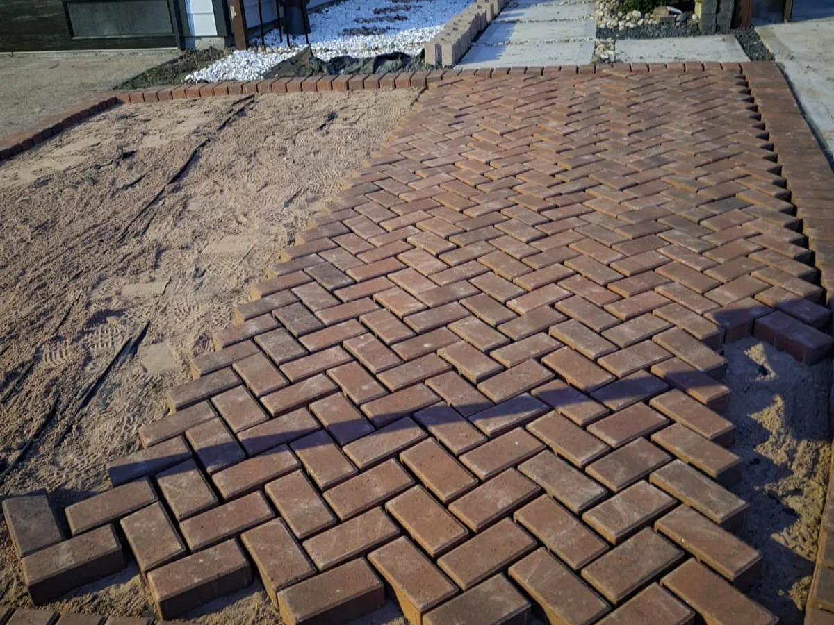 Herringbone brick paver walkway to a front door